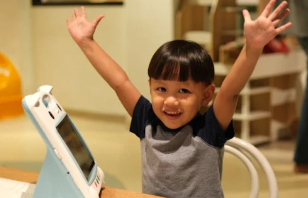 Seorang anak tersenyum antusias saat menggunakan Wink Smart Learning di rumah