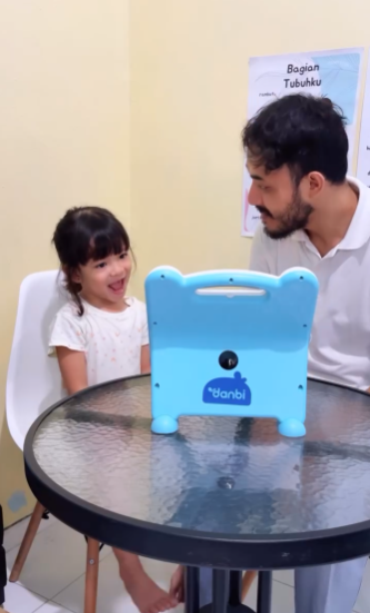 Anak dan ayah sedang belajar bersama menggunakan Wink.